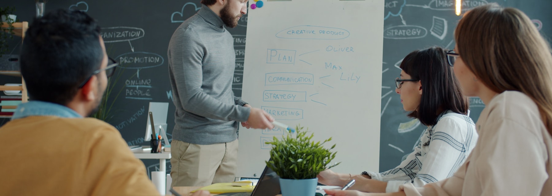 Sirius consultants collaborating around a whiteboard in a modern office